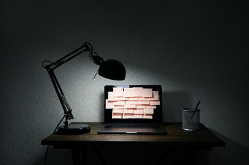 Image of laptop full of sticky notes reminders on screen. Late night work overload concept image. Working at home concept image.