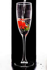 Filling up the champagne glass with strawberry isolated on a black background copy space