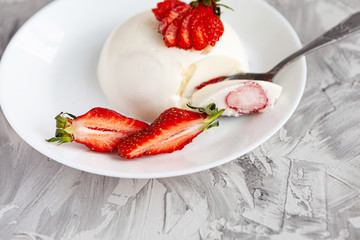 italian dessert panna cotta with fresh strawberries and a banana on a grey concrete background