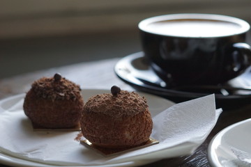 Chocolate profitroles cakes with a cup of coffee.