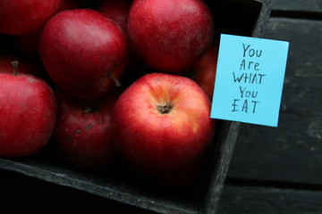 Ripe red apples in wooden box.