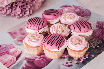 Pink cupcakes with chocolate. Lots of cupcakes for the holiday. Holiday cupcakes with cream and strawberries