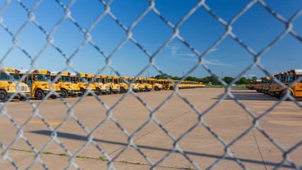 Pearland TX/USA - May 2020: Idle school buses await the reopening of K-12 schools