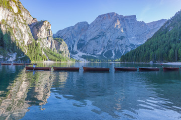 Boats moored in the centre of the Braies lake towards sunset , South Tyrol, Italy. Concept: relaxation in nature, famous natural places, film sets