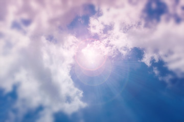 A bright ray of sunshine breaks through the white clouds. Blurred, blurry, defocused.