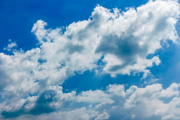 Fluffy white clouds float in the blue sky. Divine view.