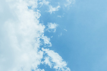Fluffy white clouds on a clear blue background float in the sky. Divine view. Copy space.