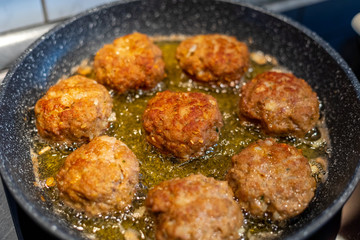Raw meat cutlets rissole meatballs of minced pork in a pan.
