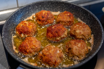 Raw meat cutlets rissole meatballs of minced pork in a pan.