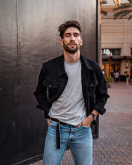 Portrait of a handsome man standing on the street, Fashion model standing in front of shopping mall.