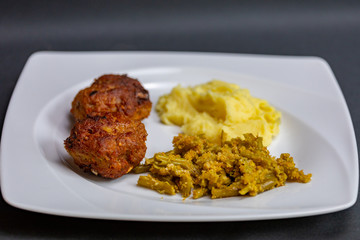 close up meatballs,mashed and green beans potatoes in plate