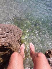 Feet hanging over cliff in Nice France