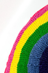 Close up of a knitted item in the shape of a rainbow, Space for copy top left.