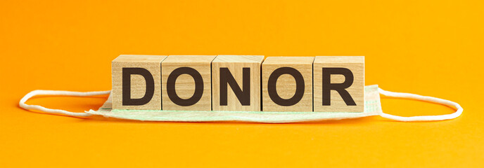 DONOR the word is written on wooden cubes lying on a medical mask. Concept