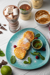 Fresh cheesecakes with berries with honey and hot chocolate