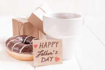 Gift box with a tag, cup of coffee or tea. Father's day or birthday concept.