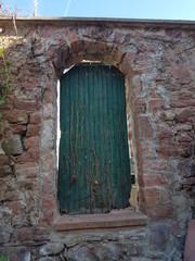 Fototapeta na wymiar grüne Holztür in alter Steinmauer