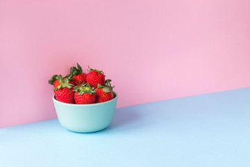 Strawberries on a light blue and pink background. Copy space available..
