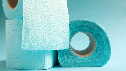 Blue roll of modern toilet paper on a blue background. A paper product on a cardboard sleeve, used for sanitary purposes from cellulose with cutouts for easy tearing. Embossed drawing