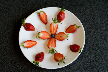 Sliced strawberries are decoratively placed on a white plate