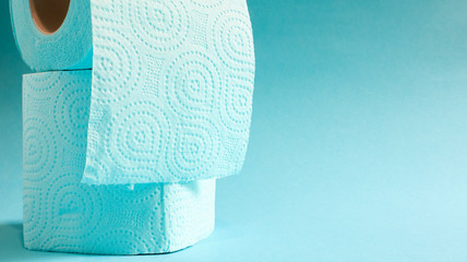 Blue roll of modern toilet paper on a blue background. A paper product on a cardboard sleeve, used for sanitary purposes from cellulose with cutouts for easy tearing. Embossed drawing. copy space.