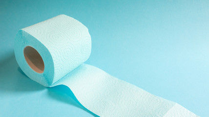 Blue roll of modern toilet paper on a blue background. A paper product on a cardboard sleeve, used for sanitary purposes from cellulose with cutouts for easy tearing. Embossed drawing. copy space.