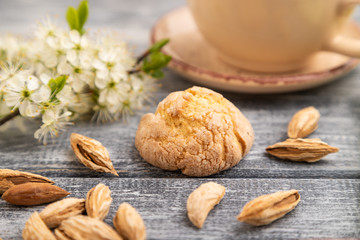 Almond cookies and a cup of coffee on a gray wooden background. Side view, selective focus.