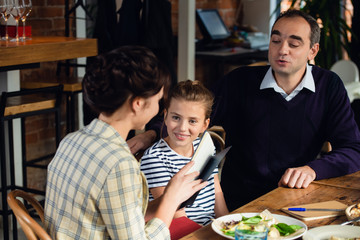 A happy family exchanging presents at a large dinner table