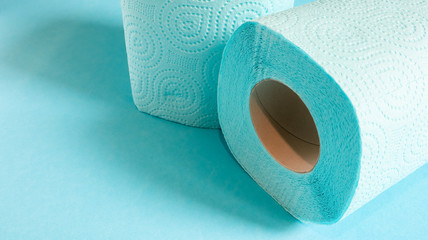 Blue roll of modern toilet paper on a blue background. A paper product on a cardboard sleeve, used for sanitary purposes from cellulose with cutouts for easy tearing. Embossed drawing. copy space.