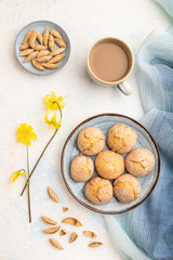 Almond cookies and a cup of coffee on a white concrete background Top view, close up.