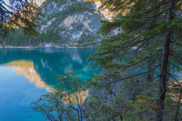 Beautiful mountains reflections on the Braies lake crystalline waters seen from fir forest, South Tyrol, Italy. Concept: relaxation in nature, famous natural places, film sets