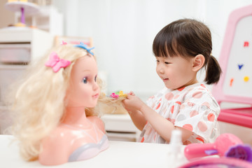 Obraz na płótnie Canvas toddler girl pretend play as hairdresser at home