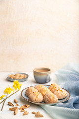 Almond cookies and a cup of coffee on a white concrete background Side view, selective focus, copy space.
