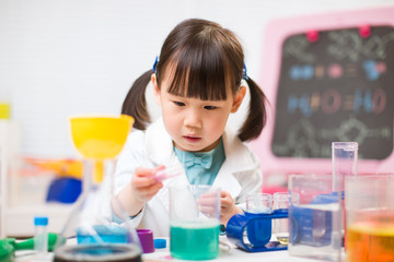 toddler girl pretend play  scientist  role  at home against white background