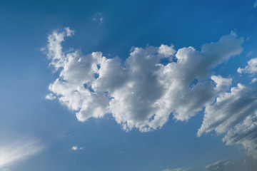 Lonely white cumulus cloud in a blue spring sky. Nature background.