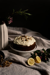 dark moody setting with carrot cake, lemons and nuts