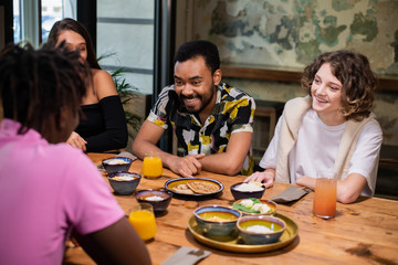 Multi-ethnic group of friends having a good time in a cafe