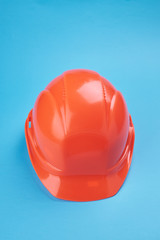 Fototapeta premium orange protective helmet and safety glasses near it on a bright blue background. protective workwear and construction industry concept.