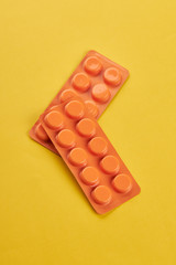 medical wellness concept. orange pills on a yellow background. copy space. minimal.