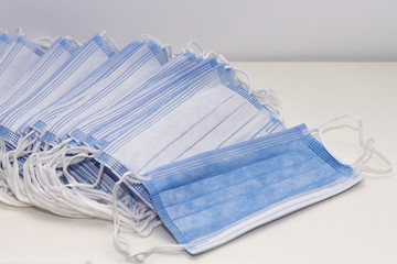 A pile of blue and white disposable face masks