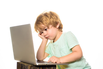 Learning concept. Boy spending time with notebook and modern technology. Little boy with laptop computer or notebook at home. Internet, homework and social media. Cute kid playing computer at home.