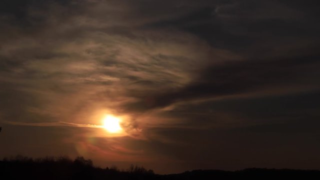 Time lapse amazing sunset shining through soft clouds going to darkness. 4K