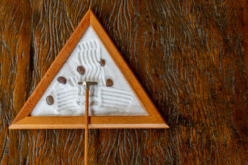 small zem garden in triangle shape, with five stones, on wooden table