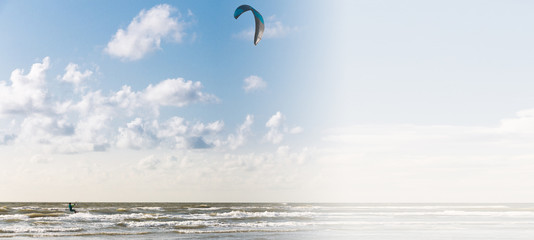 Image of a kite surfer sailing on the beach with a gradient to white to the right leaving copy space