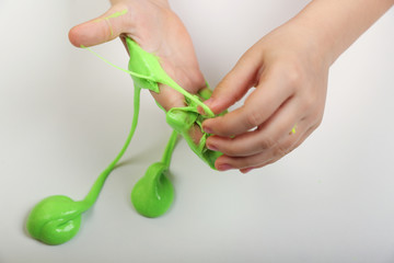 child's hands are playing with a slime on a white background
