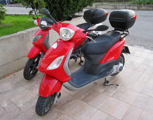 A red scooter is parked in the Parking lot