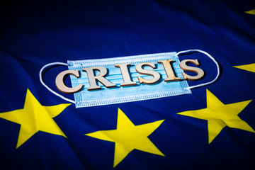 flat face mask on a European flag with wooden letters forming words to create a concept