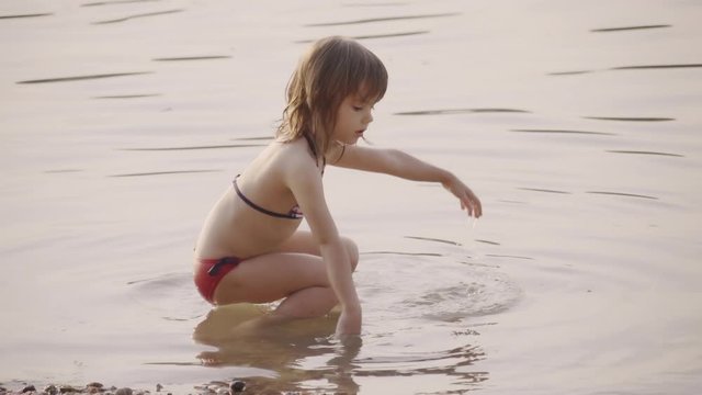 Girl wearing bikini playing in shallow water