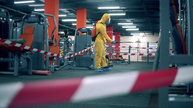 Disinfector is sanitizing fitness center with chemicals