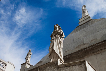 Three sculptures caring for a grave in the Recoleta cemetery in Buenos Aires